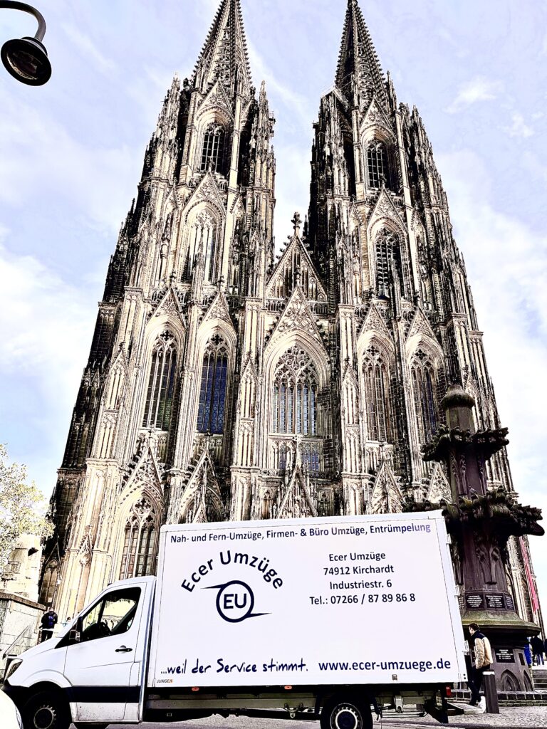 Umzugs-LKW von Ecer Umzüge vor der imposanten Fassade des Kölner Doms geparkt, mit gut sichtbarem Firmenlogo und Kontaktdaten auf der Seitenfläche.