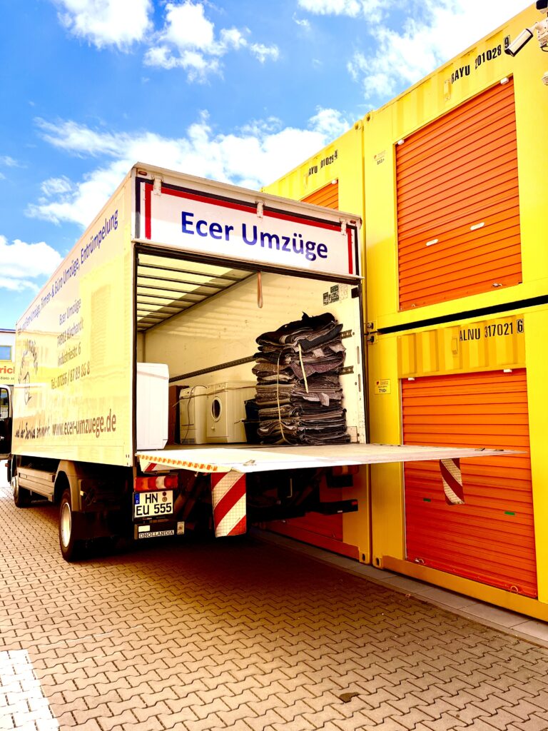 Ecer Umzüge bei der Einlagerung von Möbeln – Umzugswagen vor Lagercontainern mit geladenem Umzugsgut