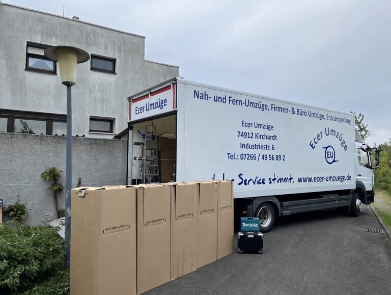 Ecer Umzüge beim Hausumzug – Umzugswagen und verpackte Möbelkartons vor einem Wohnhaus