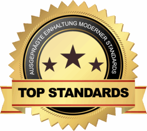 Goldenes Qualitätssiegel mit Sternen und dem Schriftzug „Top Standards – ausgeprägte Einhaltung moderner Standards“.